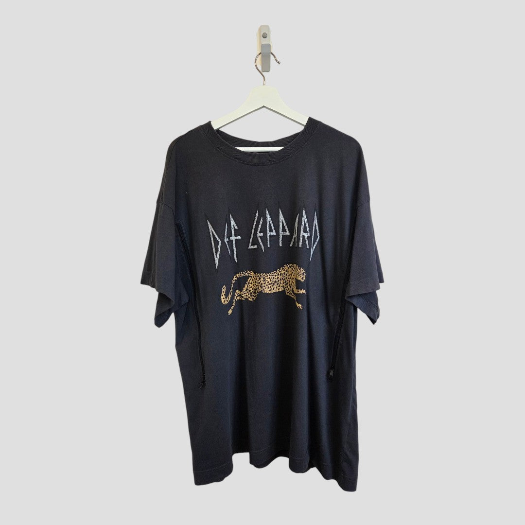 Grey Def Leppard Band t-shirt (XL) by H&M, upcycled for breastfeeding and pumping, featuring stylized band text and a leopard graphic, displayed as affordable maternity wear on a white hanger against a plain grey background.