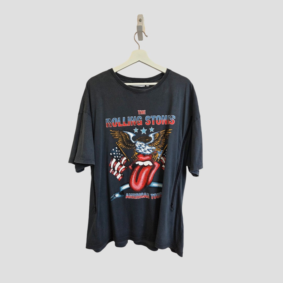 Next Upcycled Breastfeeding (Nursing) & Pumping Grey The Rolling Stones Eagle Band t-shirt in size XL (100607)—featuring a striking graphic of an eagle, American flags, and the legendary red tongue logo—hangs on a white hanger against a simple background. This affordable and stylish upcycled t-shirt from Next is the perfect choice for pairing with your favorite jeans or as comfortable casual nursing wear for new moms.