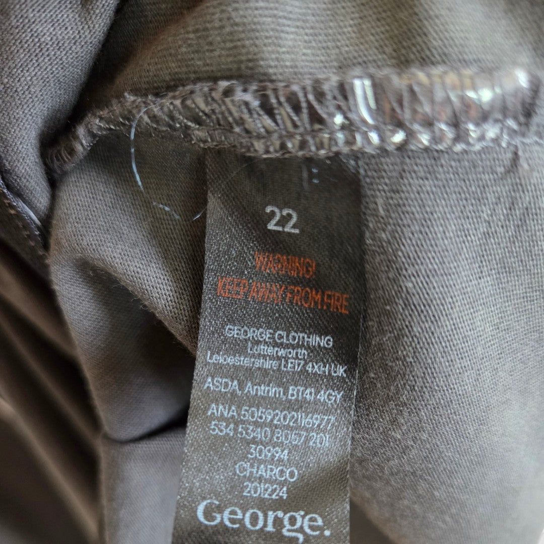 Close-up of a clothing label on a grey Iron Maiden band t-shirt, upcycled for breastfeeding (nursing) and pumping in UK size 22, featuring fire safety information, manufacturer’s details, and the George brand—showcasing comfortable, affordable nursing wear with unique style.