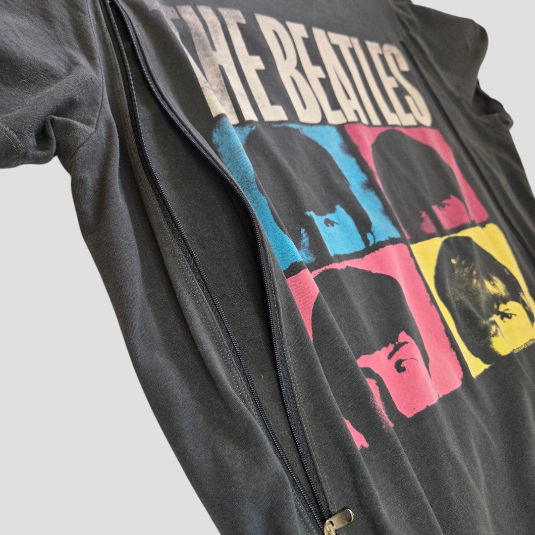 An upcycled breastfeeding and pumping T-shirt by Amplified features The Beatles text and pop-art colored blocks with the band members’ faces.