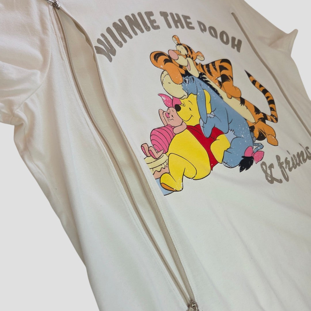 Primark Upcycled Breastfeeding (Nursing) & Pumping Cream Winnie the Pooh & Friends t-shirt, size L (UK14/16), featuring playful graphics of Winnie the Pooh, Tigger, Piglet, and Eeyore, with visible silver zippers on each side for convenient nursing and pumping access. This affordable top blends whimsical style with practical design for easy breastfeeding.