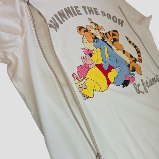 Primark Upcycled Breastfeeding (Nursing) & Pumping Cream Winnie the Pooh & Friends t-shirt, size L (UK14/16), featuring playful graphics of Winnie the Pooh, Tigger, Piglet, and Eeyore, with visible silver zippers on each side for convenient nursing and pumping access. This affordable top blends whimsical style with practical design for easy breastfeeding.