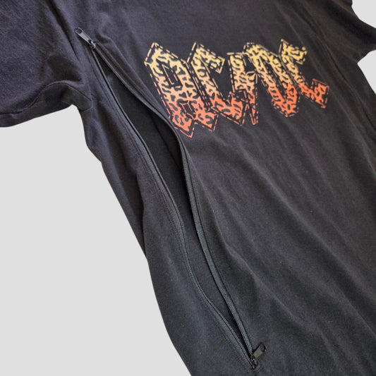 Upcycled Breastfeeding (Nursing) & Pumping Black Leopard AC/DC Band t-shirt (size M) by AC/DC, featuring a bold orange-yellow graphic text on black fabric and a large diagonal zipper from the side to the bottom for convenient breastfeeding access, displayed on a light gray background.