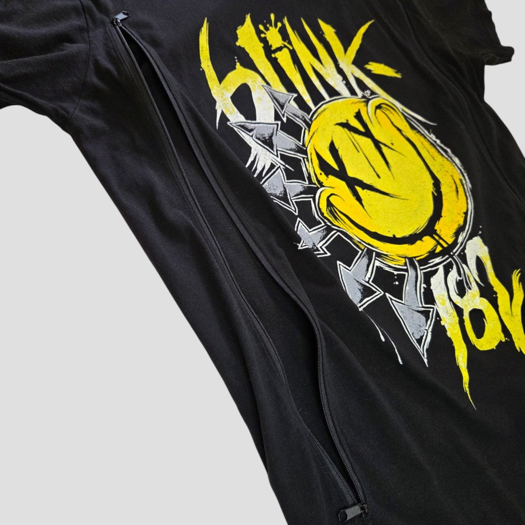 Upcycled Blink-182 Breastfeeding (Nursing) & Pumping Black/Yellow Smile Band t-shirt (size L) by Blink-182, featuring a yellow smiley face graphic and band text. Designed with two vertical zippers on the front for convenient nursing access—an affordable option for nursing clothing. Set against a plain, light gray background.