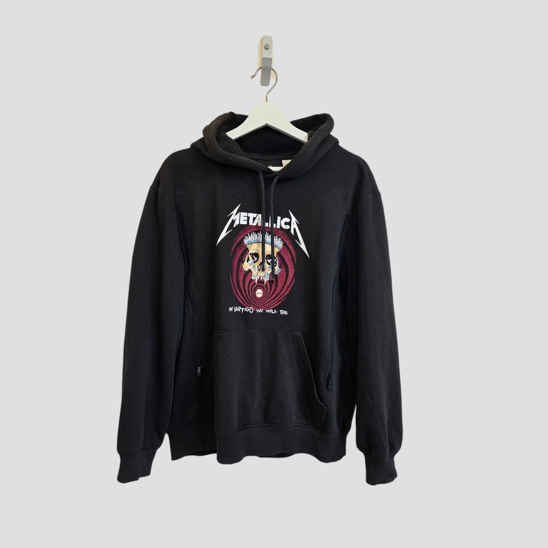 Upcycled Breastfeeding (Nursing) & Pumping Black Metallica Vertigo Band Hoodie by H&M in size M (100606), featuring a colorful face graphic and bold Metallica logo, designed as eco-friendly nursing clothing, shown hanging on a white hanger against a plain light background.