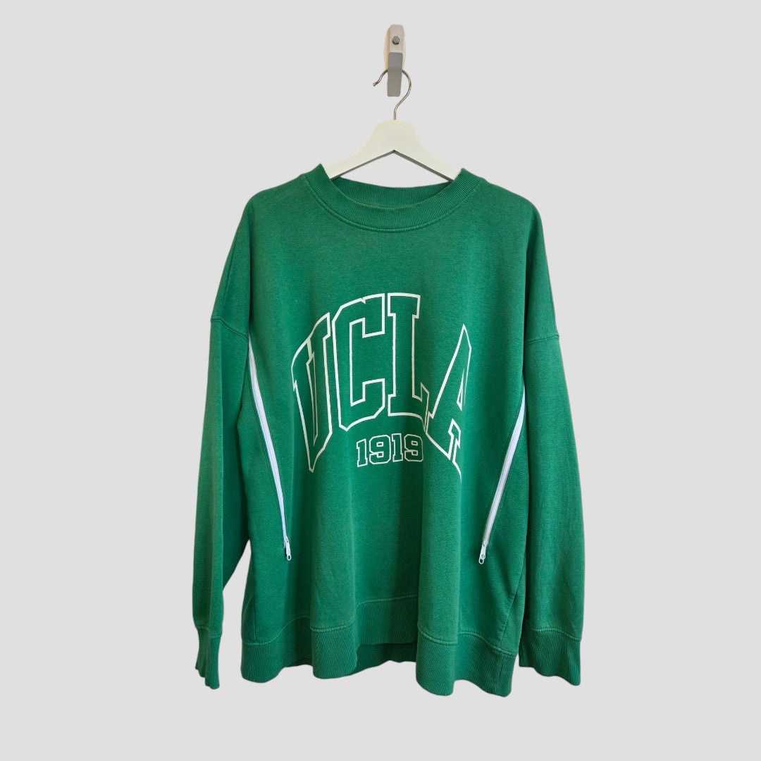 The H&M Upcycled Breastfeeding (Nursing) & Pumping Green UCLA sweatshirt L (100629) features “UCLA 1919” in white lettering, shown on a hanger against a plain light gray background—an eco-friendly and affordable choice designed for everyday comfort and style.