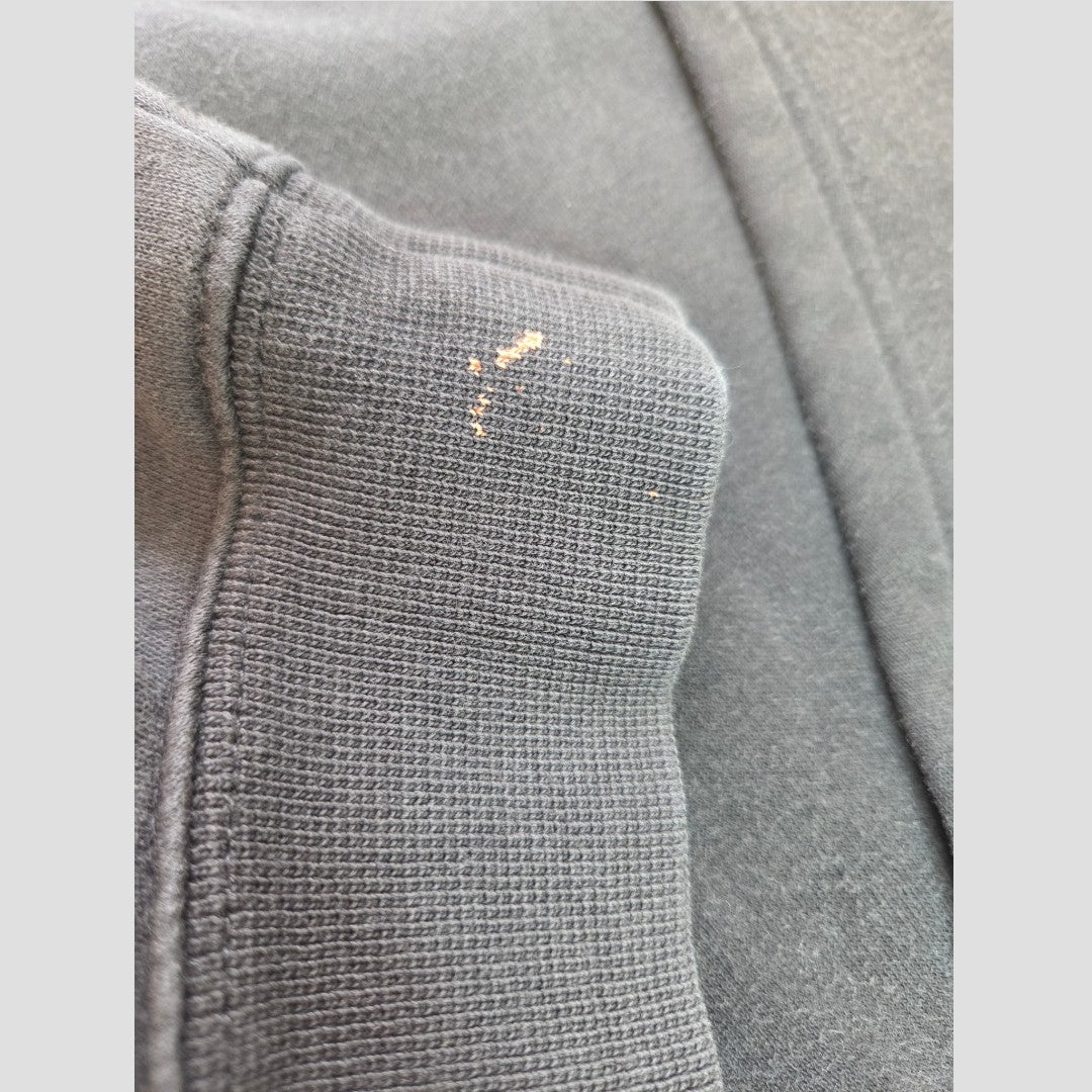 Close-up of a black Adidas hoodie sleeve with the white logo and subtle upcycled detailing on the ribbed cuff, highlighting the fabric’s texture and stitching—an example of affordable nursing and pumping wear designed for comfort and practicality (Upcycled Breastfeeding & Pumping Black Adidas White Logo Hoodie UK16).