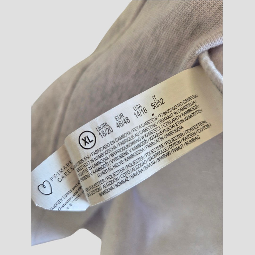 A close-up of a white clothing tag showing size XL and care instructions in multiple languages, attached to an affordable Primark Upcycled Breastfeeding & Pumping Grey Tweety sweatshirt (size XL, UK18/20).