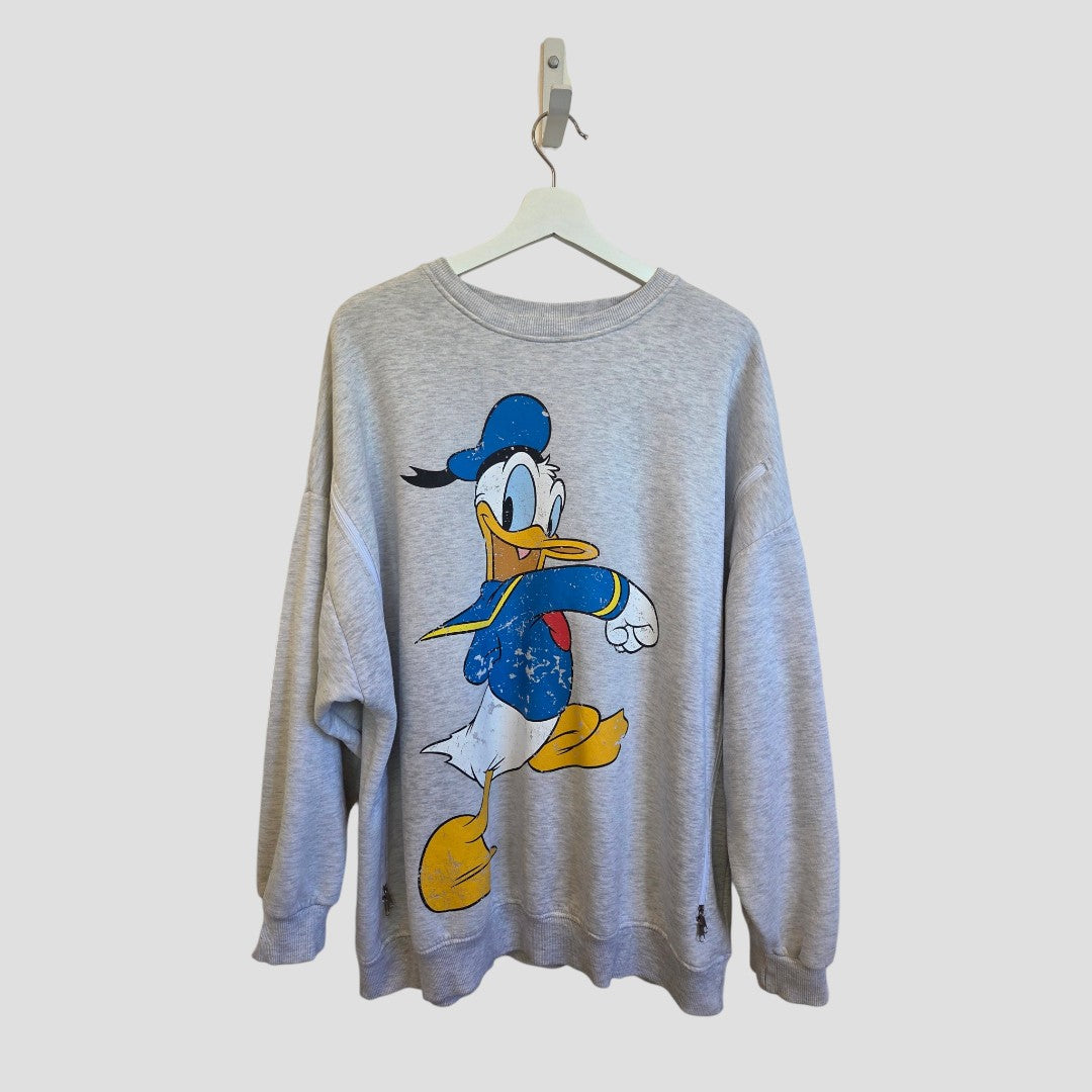 Primark Upcycled Breastfeeding & Pumping Grey Disney Donald Duck sweatshirt (size L, UK14/16) features a large graphic of Donald Duck in his classic blue hat and jacket, displayed on a white hanger against a simple light background. This affordable nursing wear combines comfort with playful Disney style—an ideal addition to your maternity wardrobe.