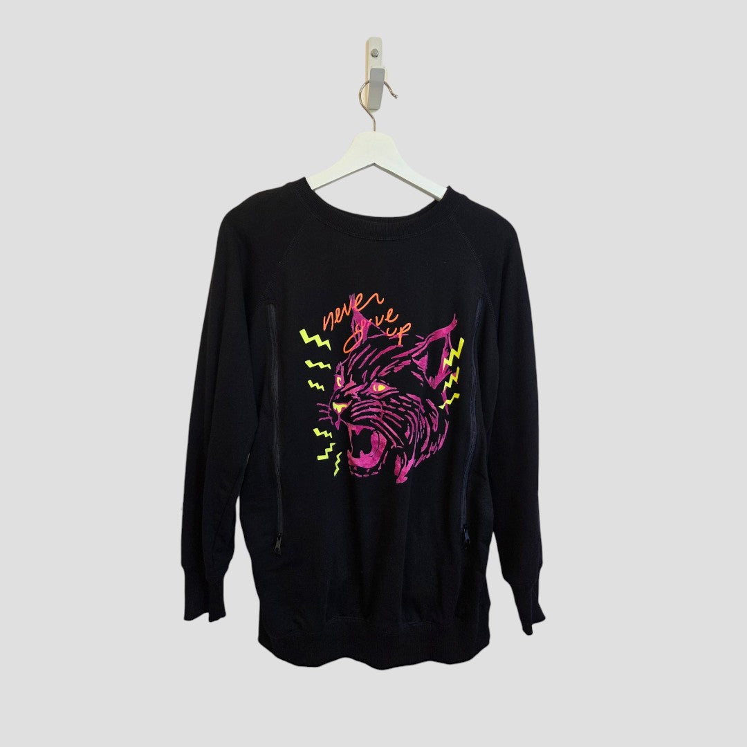 Upcycled Breastfeeding (Nursing) & Pumping Black Tiger Maternity Sweatshirt by Nine+ Quarter, size M (100648), displayed on a hanger. This organic cotton maternity sweatshirt features a striking neon pink and yellow roaring cat graphic with zigzag accents and the words “never give up” above it. Expertly designed to provide bold style and everyday comfort for mums-to-be.