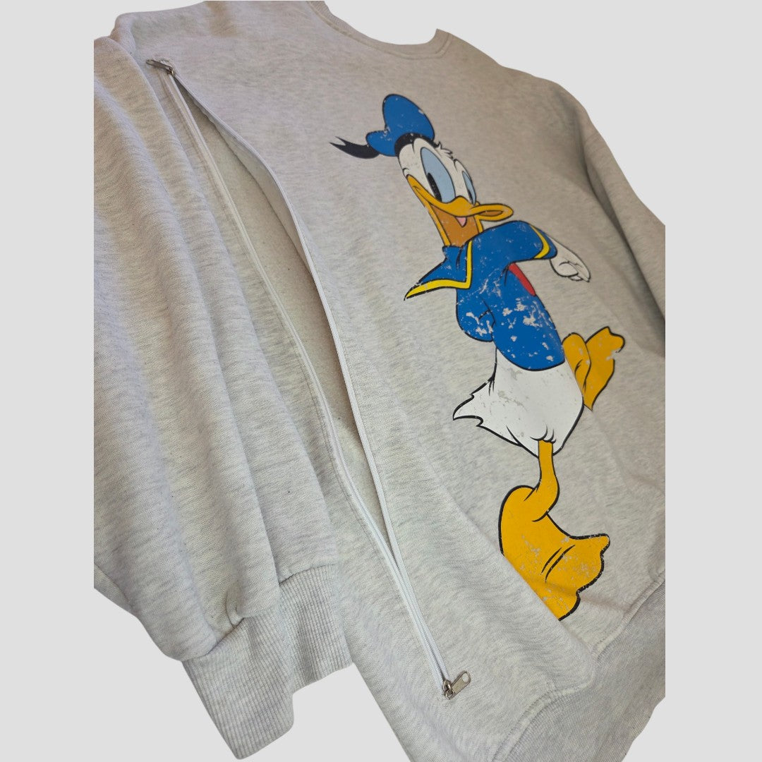 Primark’s Upcycled Breastfeeding (Nursing) & Pumping Grey Disney Donald Duck sweatshirt (L, UK14/16) features a light gray design with a graphic of Donald Duck in his classic blue sailor outfit and a practical side zipper along the left side—making it a stylish and affordable option for nursing wear or breastfeeding clothing.