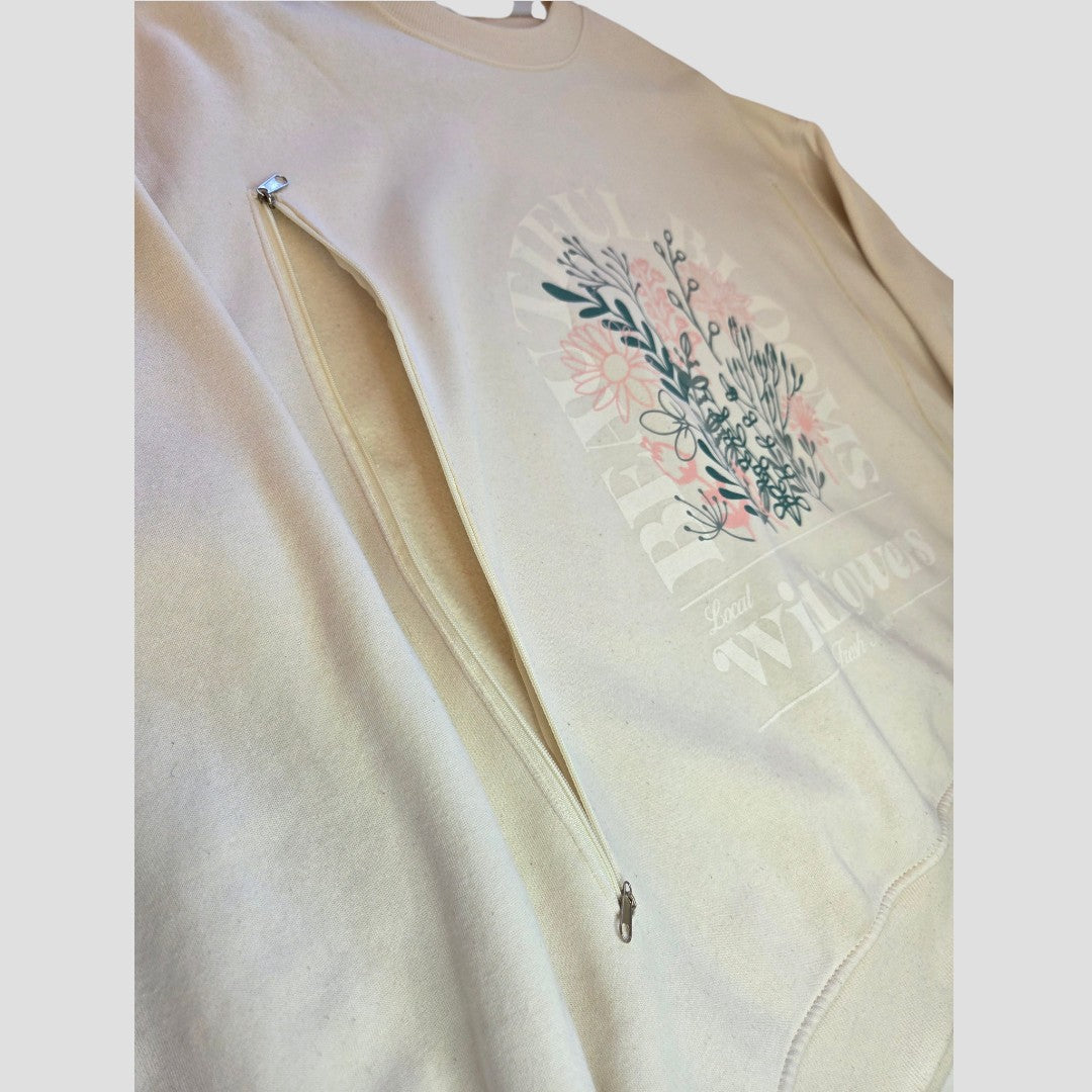 Introducing the Upcycled Breastfeeding (Nursing) & Pumping Cream Wildflowers Sweatshirt XL (100645) by Primark—a stylish cream sweatshirt featuring a side zipper for discreet and easy breastfeeding access. The floral graphic design showcases pink and green wildflowers with the phrase “Real wildflowers,” making it both practical nursing clothing and fashion-forward.