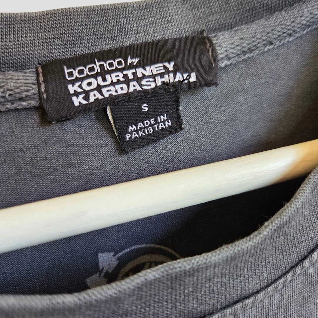 A size small nursing clothing tag attached to the neckline of a grey Upcycled Breastfeeding (Nursing) & Pumping Grey Blink-182 Oversized Band t-shirt S (100622) by boohoo.