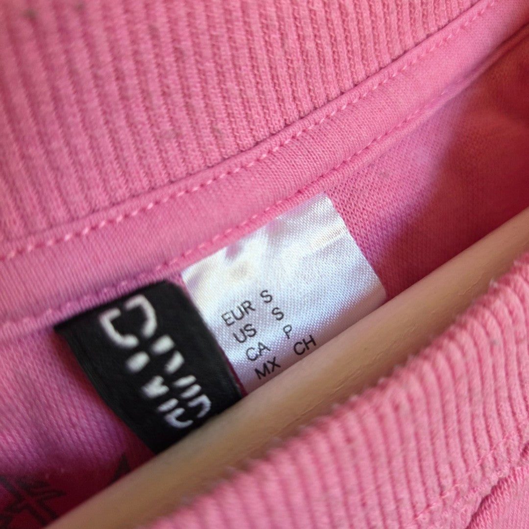 Neck labels on an Upcycled Breastfeeding (Nursing) & Pumping Pink Def Leppard Band sweatshirt S (100651) showing the H&M brand tag and a size small tag.