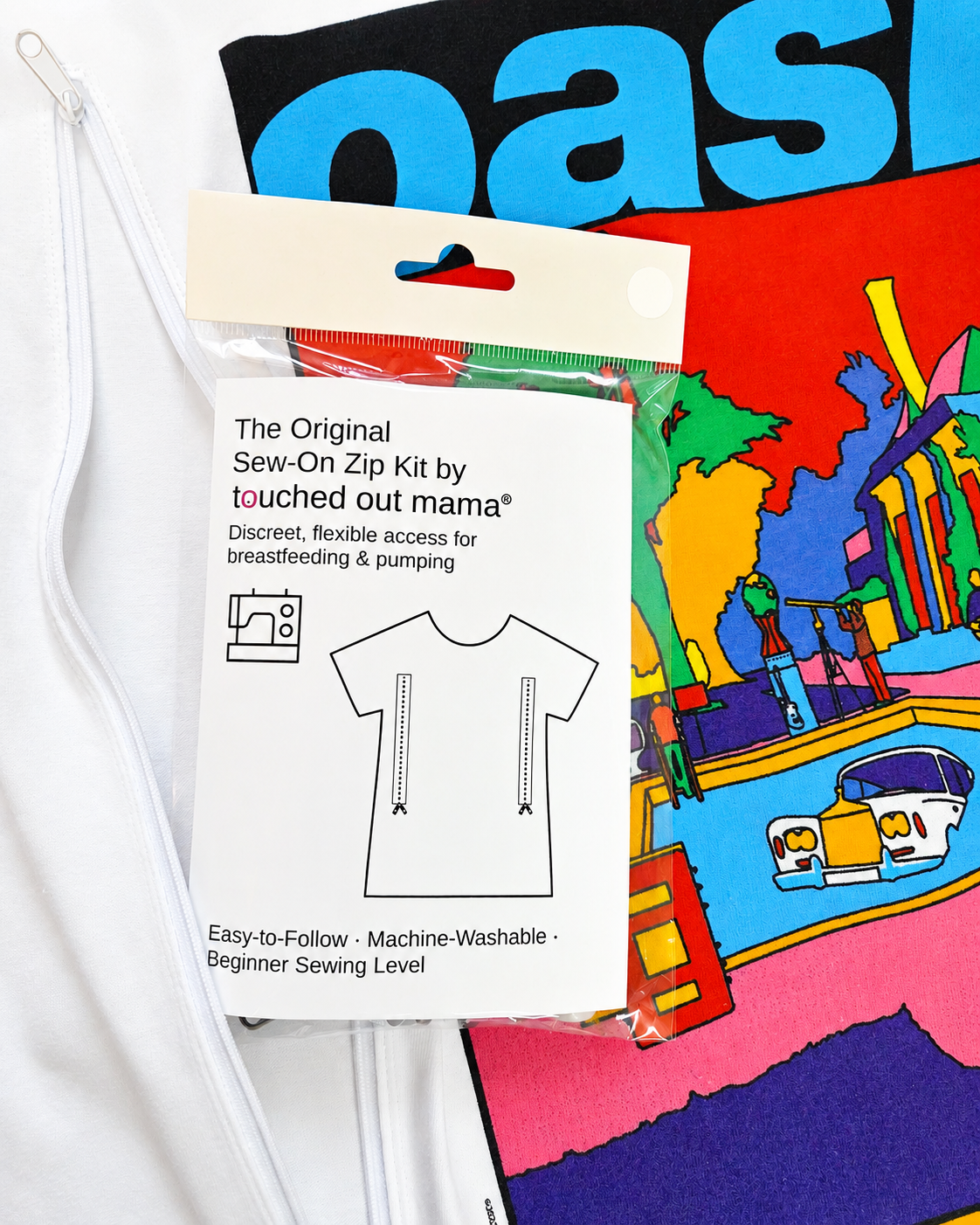 The Original Sew-On Zip Kit for Breastfeeding & Pumping Access by touched out mama sits on a vibrant upcycled T-shirt, providing discreet, flexible nursing access. Includes machine-washable materials and beginner-friendly instructions.
